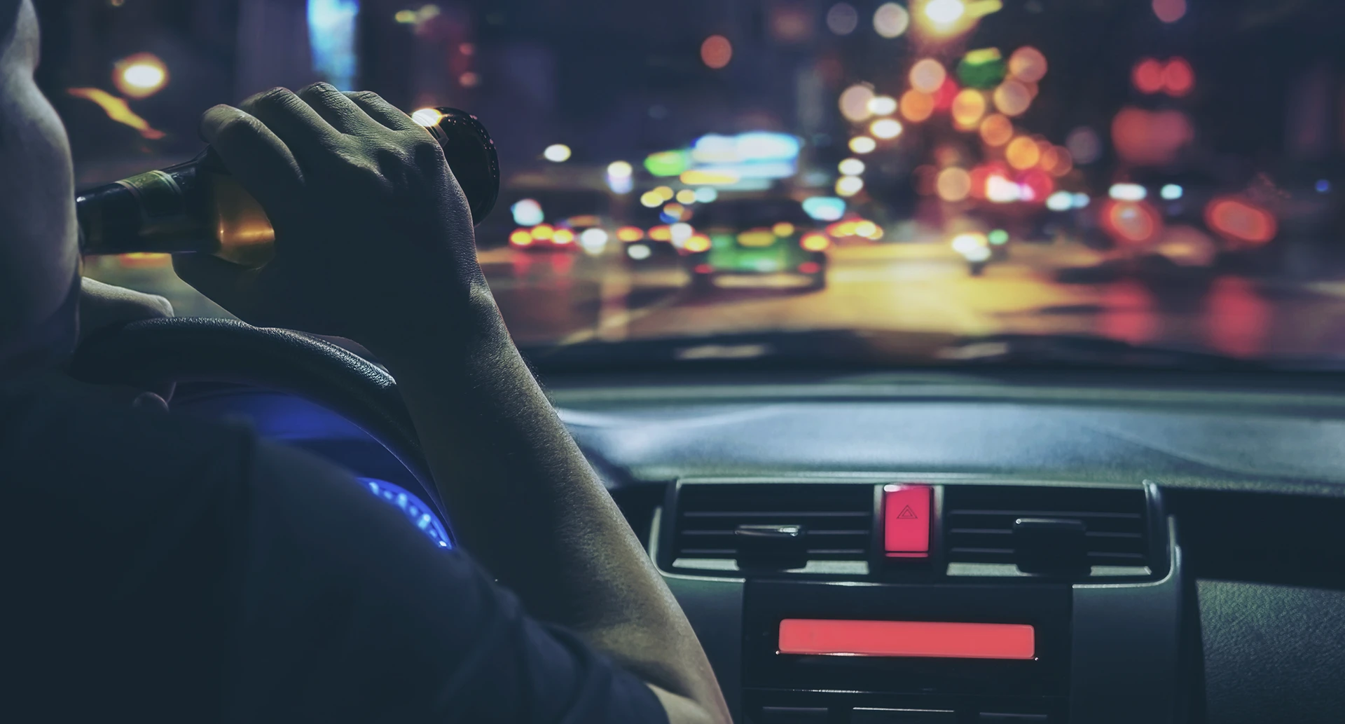 driver holding a beer bottle to their face while driving a car leading to a dui